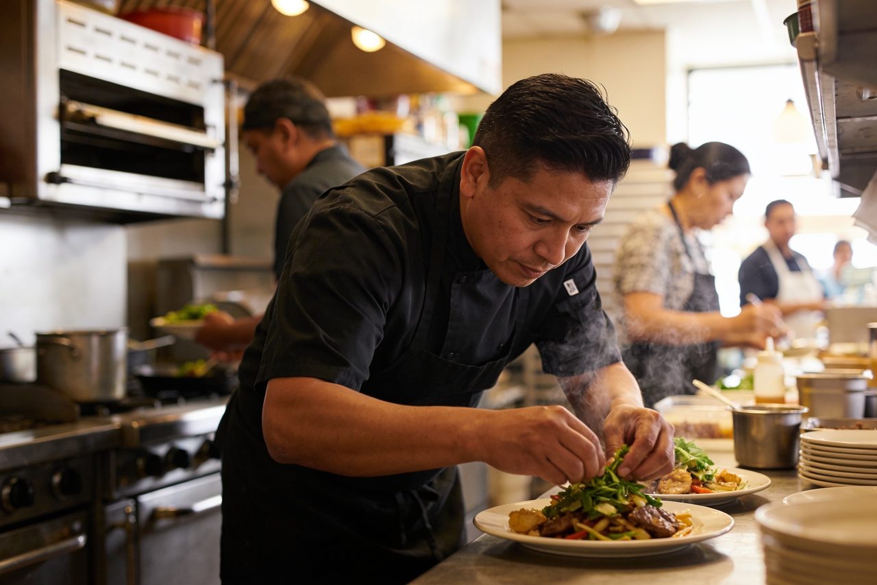 Restaurant owner plating fresh food in his kitchen